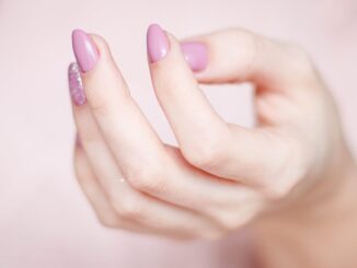 person s hand with pink manicure